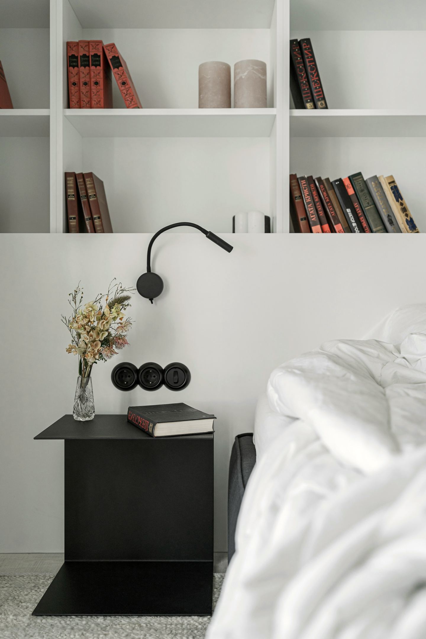 Chambre aux finitions soignées, bibliothèque blanche et chevet noir
